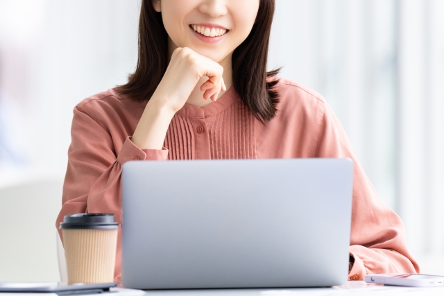 パソコンを笑顔で操作する女性